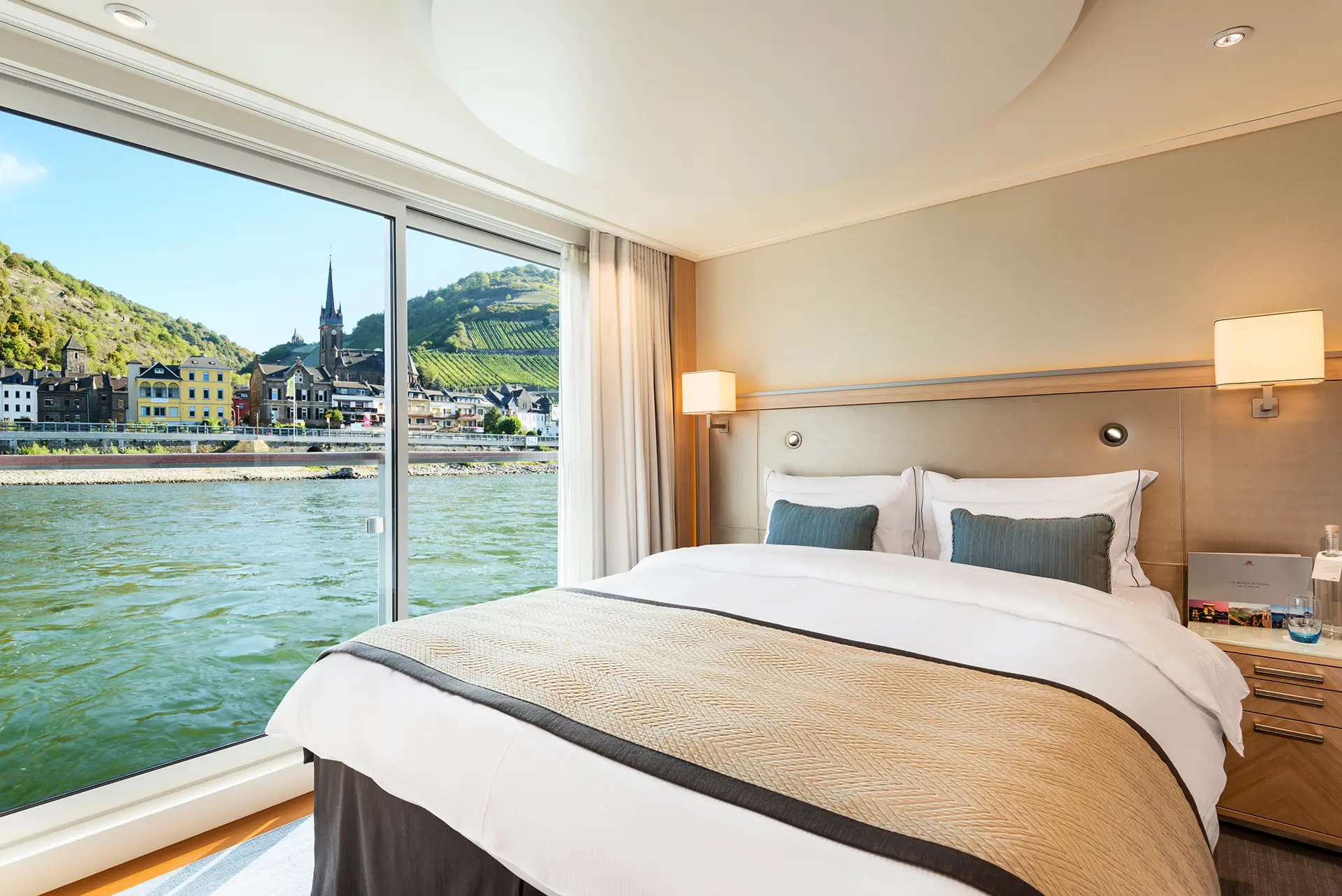 Veranda Suite bedroom on-board the Viking Longship Hlin. The town of Lorch am Rhein of the Upper Middle Rhine Valley, Germany is seen outside the window.